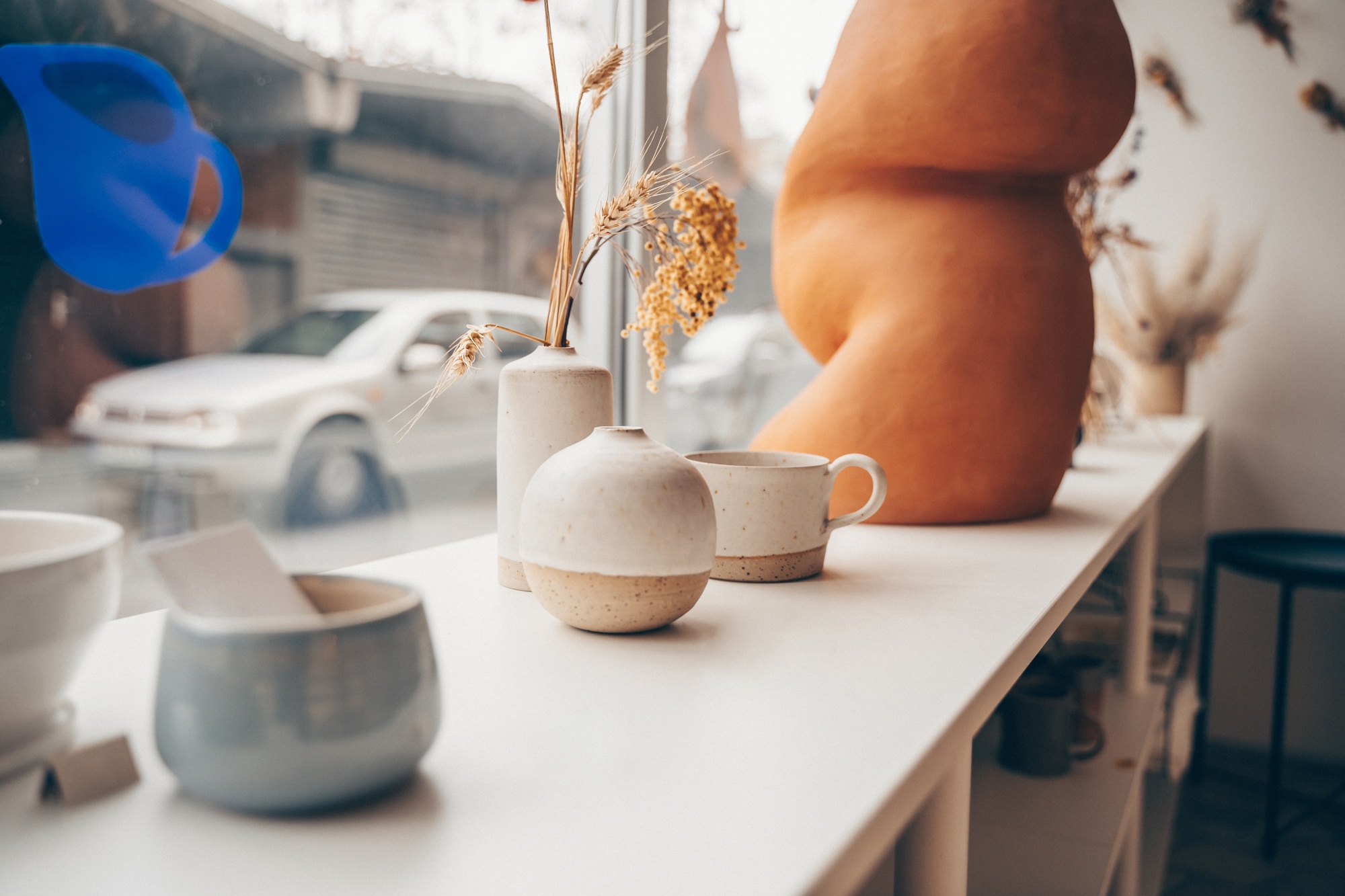 Pottery tablewares on shelves of small art shop.